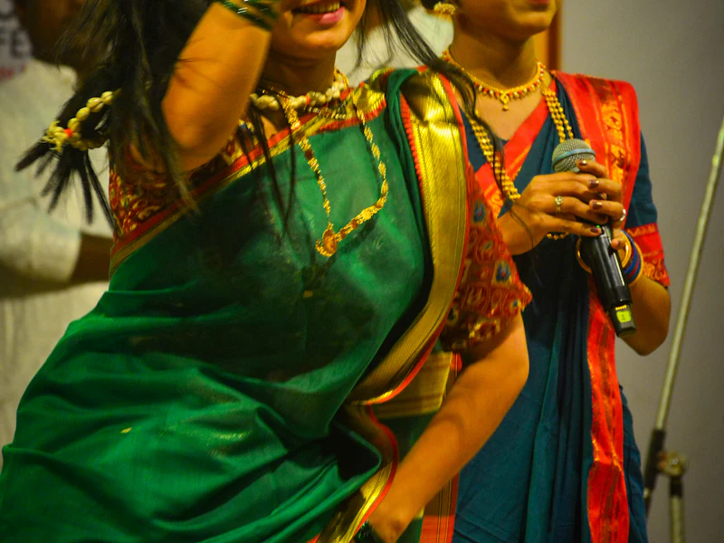 Two dancers in saris performing on stage.
